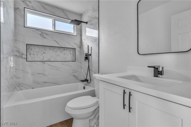 full bathroom with hardwood / wood-style flooring, vanity, toilet, and tiled shower / bath