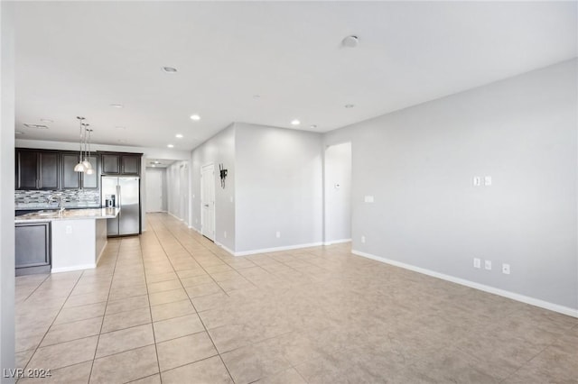 unfurnished living room with light tile patterned floors and sink