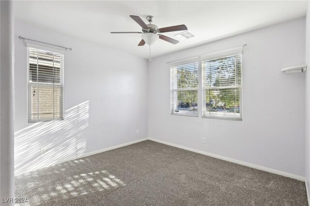 carpeted spare room with ceiling fan