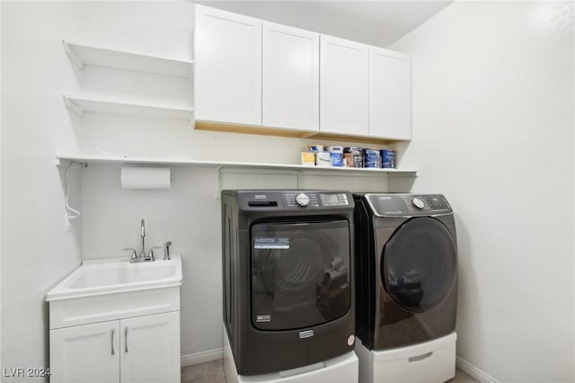 washroom featuring cabinets, sink, and washing machine and clothes dryer