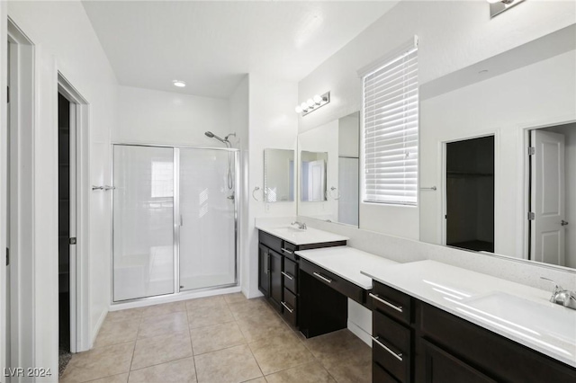 bathroom featuring tile patterned flooring, vanity, and a shower with shower door