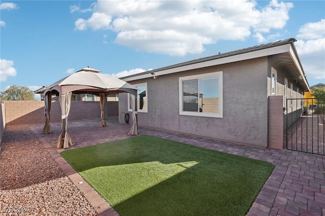 back of house with a gazebo, a patio area, and a yard