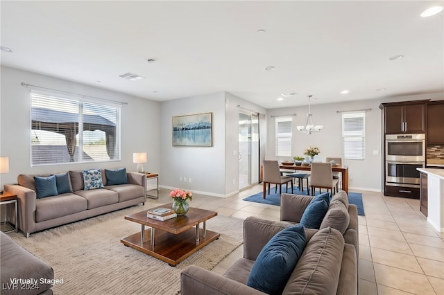 living room with a chandelier and light tile patterned flooring