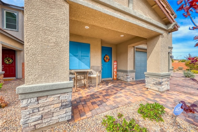 entrance to property featuring a garage and a patio