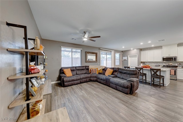 living room with ceiling fan and light wood-type flooring