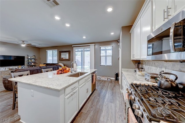 kitchen featuring white cabinetry, sink, light stone counters, and stainless steel appliances