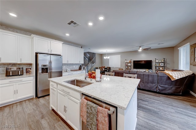 kitchen featuring stainless steel appliances, sink, a kitchen island with sink, white cabinetry, and light hardwood / wood-style flooring