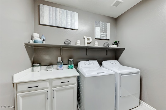 laundry area with cabinets and washing machine and clothes dryer