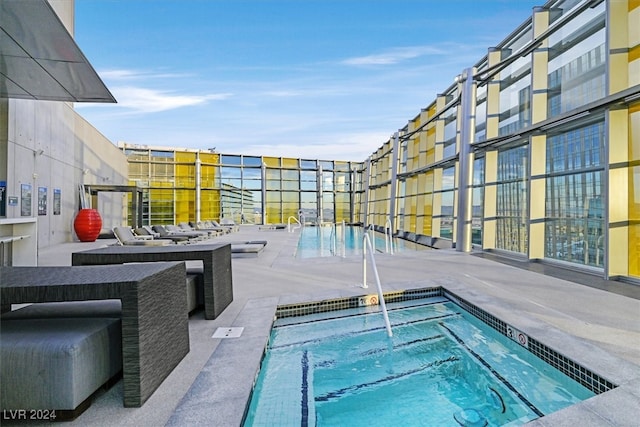 view of pool with a patio and a hot tub