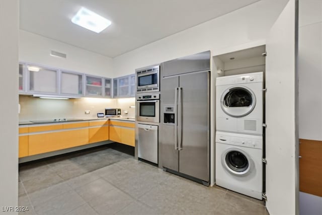 kitchen featuring stacked washing maching and dryer and built in appliances