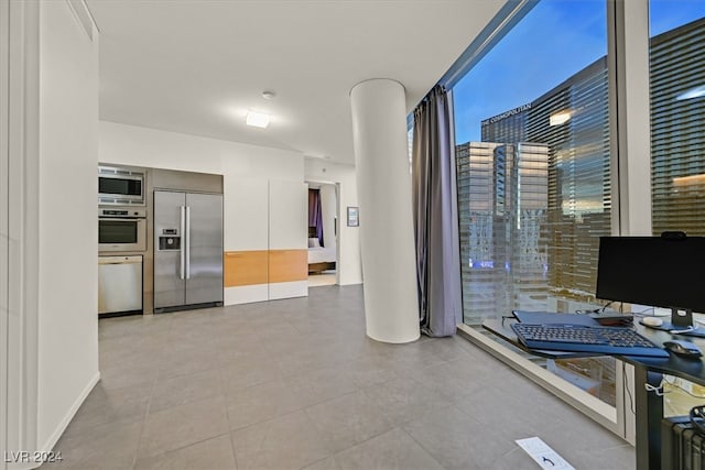 kitchen with white cabinetry, light tile patterned floors, and built in appliances