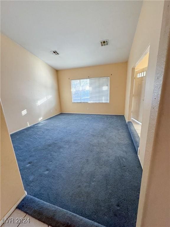 unfurnished room with dark colored carpet