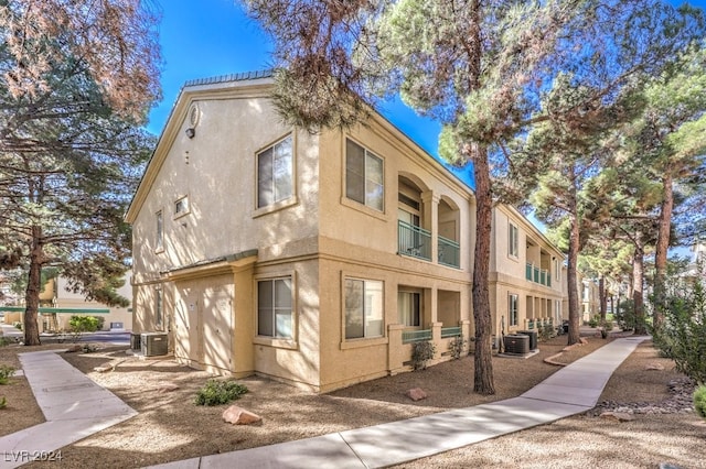 view of side of property with a balcony and central AC unit