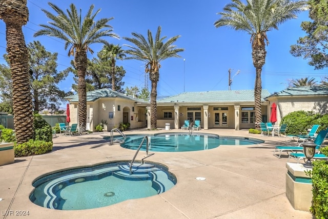 view of swimming pool featuring a patio area, a community hot tub, and french doors