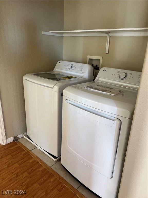 clothes washing area featuring light wood-type flooring and independent washer and dryer