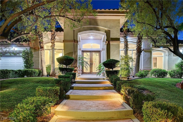 entrance to property with a lawn and a garage