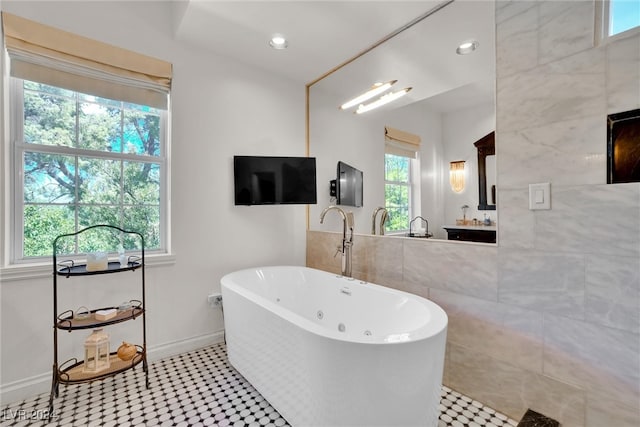 bathroom featuring tile patterned floors, a healthy amount of sunlight, and a bathing tub