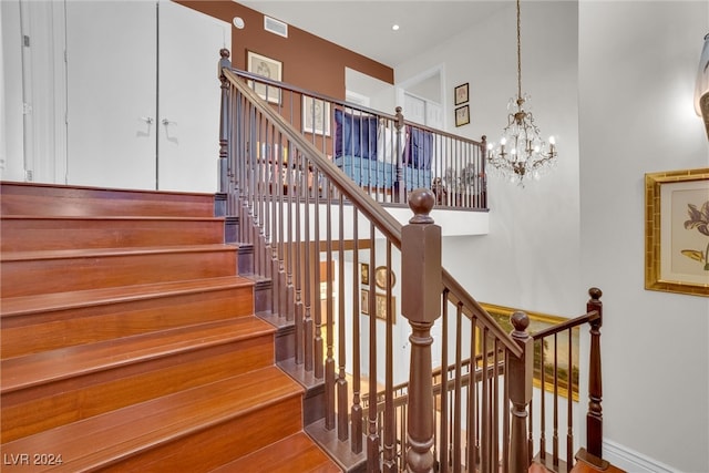 staircase featuring a chandelier