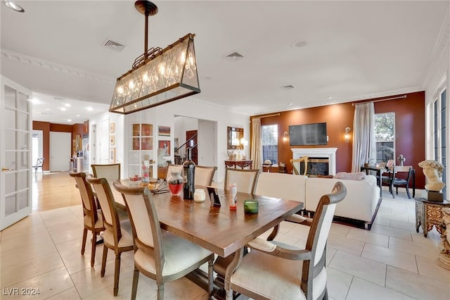 dining space featuring ornamental molding, a wealth of natural light, and light tile patterned floors