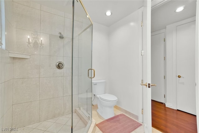 bathroom featuring hardwood / wood-style floors, toilet, and an enclosed shower