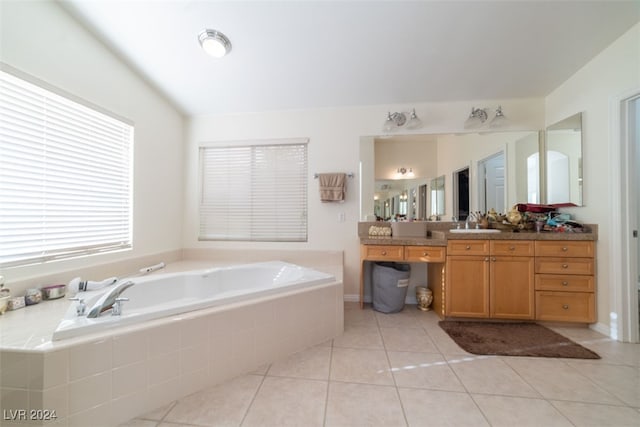 bathroom featuring tiled bath, vanity, and tile patterned floors