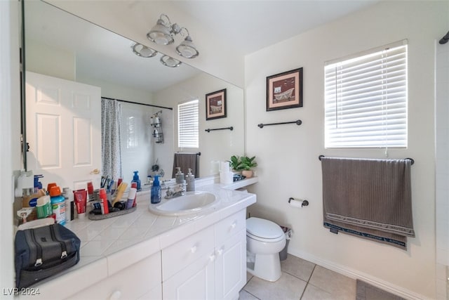 bathroom featuring vanity, a wealth of natural light, tile patterned floors, and toilet