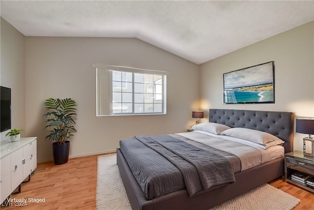 bedroom featuring light hardwood / wood-style flooring and lofted ceiling