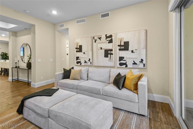 living area with visible vents and wood finished floors