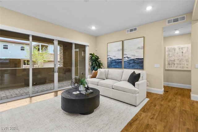 living room featuring recessed lighting, visible vents, baseboards, and wood finished floors