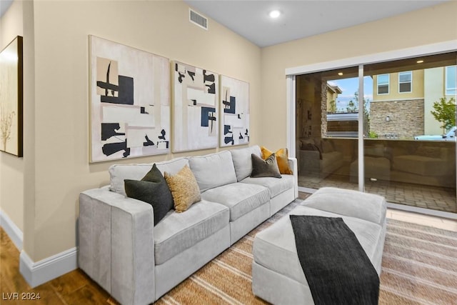 living area with recessed lighting, wood finished floors, visible vents, and baseboards