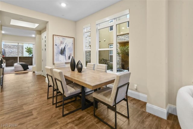 dining area with recessed lighting, a skylight, wood finished floors, and baseboards