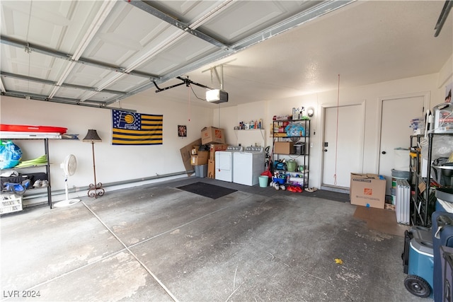 garage with a garage door opener and separate washer and dryer