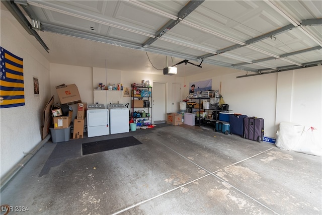 garage with a garage door opener and washer and dryer