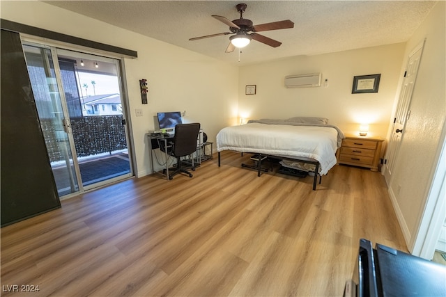 bedroom featuring access to outside, ceiling fan, wood-type flooring, and a wall mounted AC