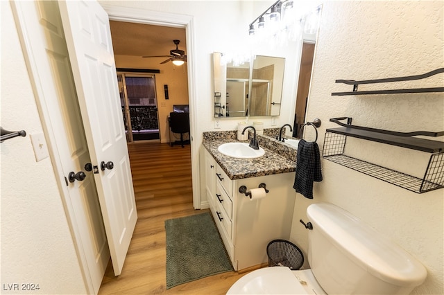 bathroom featuring ceiling fan, wood-type flooring, vanity, and toilet