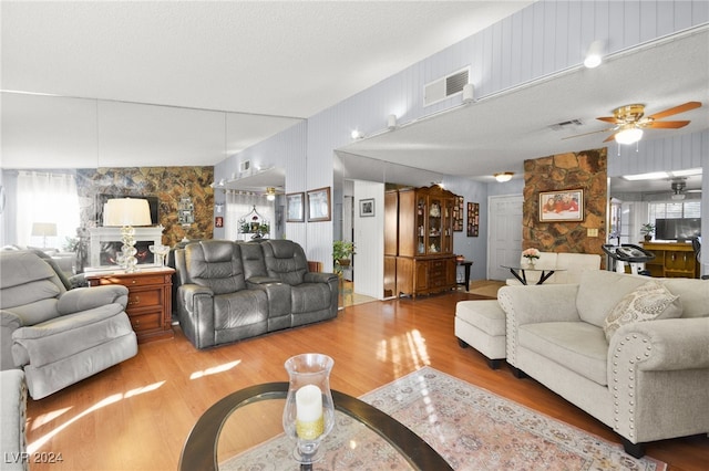 living room featuring hardwood / wood-style flooring, ceiling fan, a textured ceiling, and a wealth of natural light