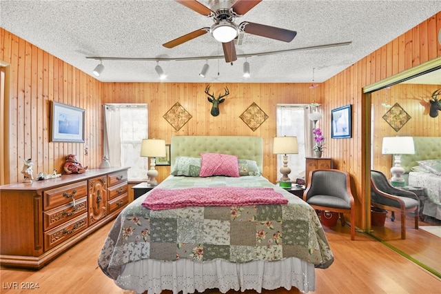 bedroom featuring multiple windows, a textured ceiling, and light hardwood / wood-style flooring