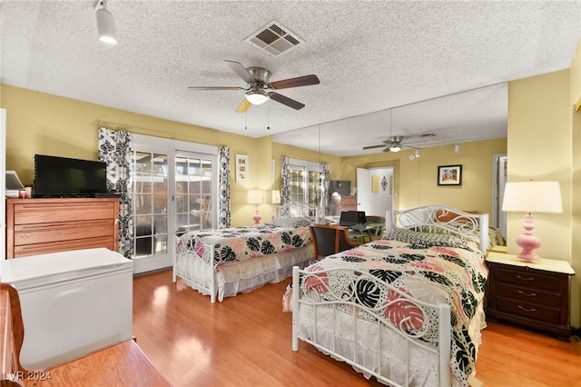 bedroom with wood-type flooring, a textured ceiling, and ceiling fan