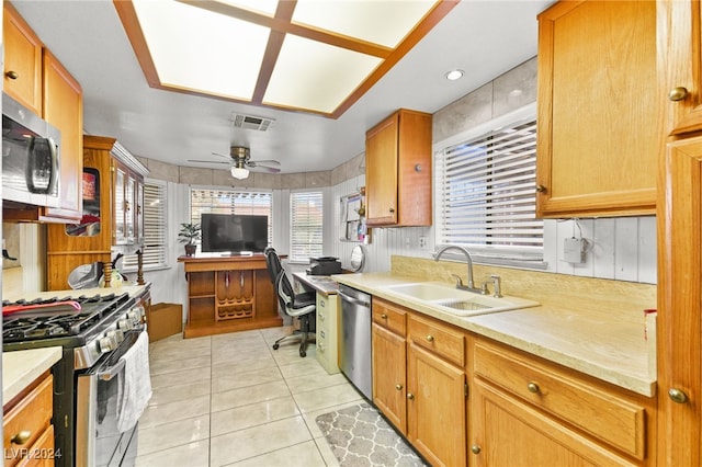 kitchen with appliances with stainless steel finishes, sink, ceiling fan, and light tile patterned flooring