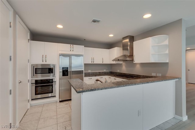 4525 Dean Martin Dr Unit 2704, Las Vegas, NV 89103 - kitchen with built in appliances, wall chimney exhaust hood, open shelves, a peninsula, and dark stone countertops
