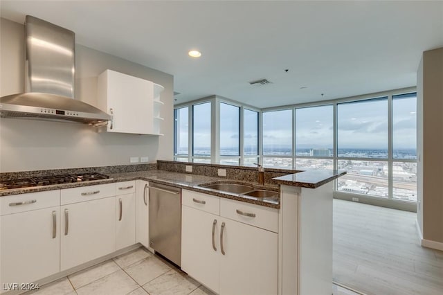 4525 Dean Martin Dr Unit 2704, Las Vegas, NV 89103 - kitchen with wall chimney exhaust hood, a sink, stainless steel appliances, dark stone countertops, and plenty of natural light