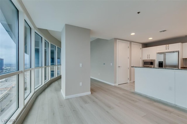 4525 Dean Martin Dr Unit 2704, Las Vegas, NV 89103 - kitchen with built in appliances, light wood-style flooring, white cabinets, recessed lighting, and baseboards