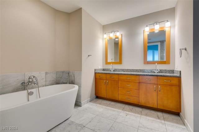 4525 Dean Martin Dr Unit 2704, Las Vegas, NV 89103 - bathroom with marble finish flooring, a freestanding bath, double vanity, and baseboards