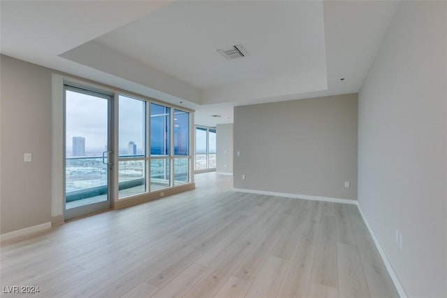 4525 Dean Martin Dr Unit 2704, Las Vegas, NV 89103 - empty room with a raised ceiling, light wood-style flooring, and baseboards