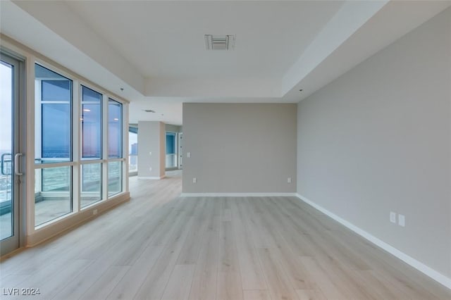 4525 Dean Martin Dr Unit 2704, Las Vegas, NV 89103 - spare room featuring a tray ceiling, light wood-style flooring, and baseboards