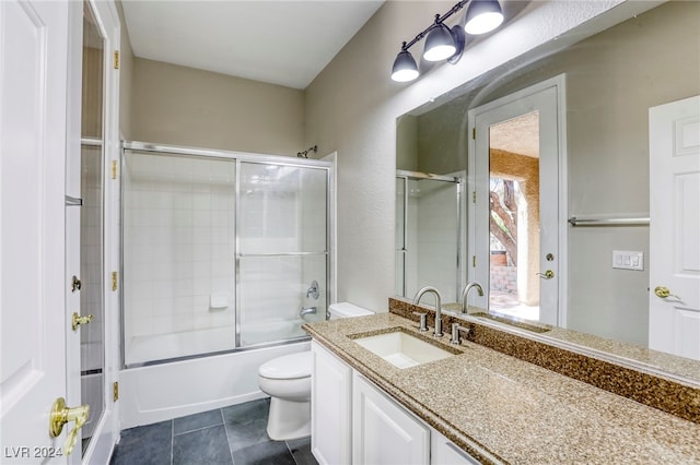 full bathroom with tile patterned floors, vanity, toilet, and shower / bath combination with glass door