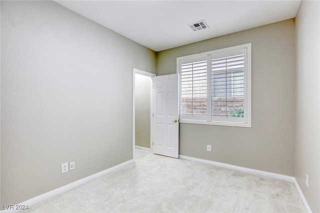 spare room featuring light carpet