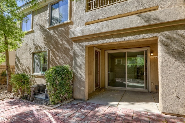 property entrance with central air condition unit and a patio area