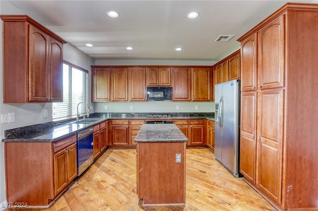 kitchen with light hardwood / wood-style floors, sink, a kitchen island, and appliances with stainless steel finishes