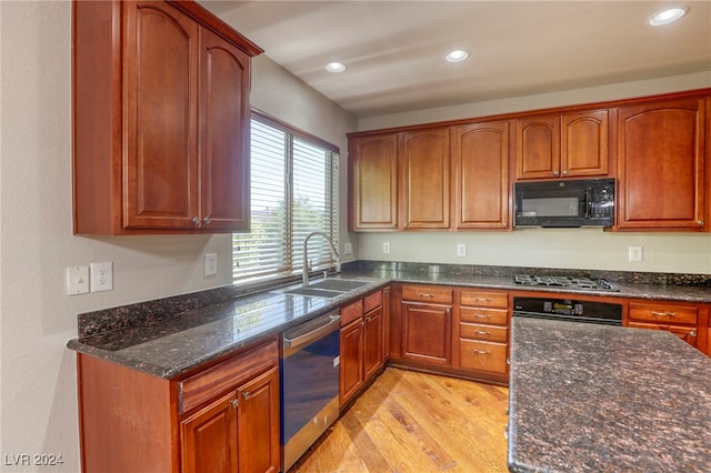 kitchen with light hardwood / wood-style floors, black appliances, sink, and dark stone countertops